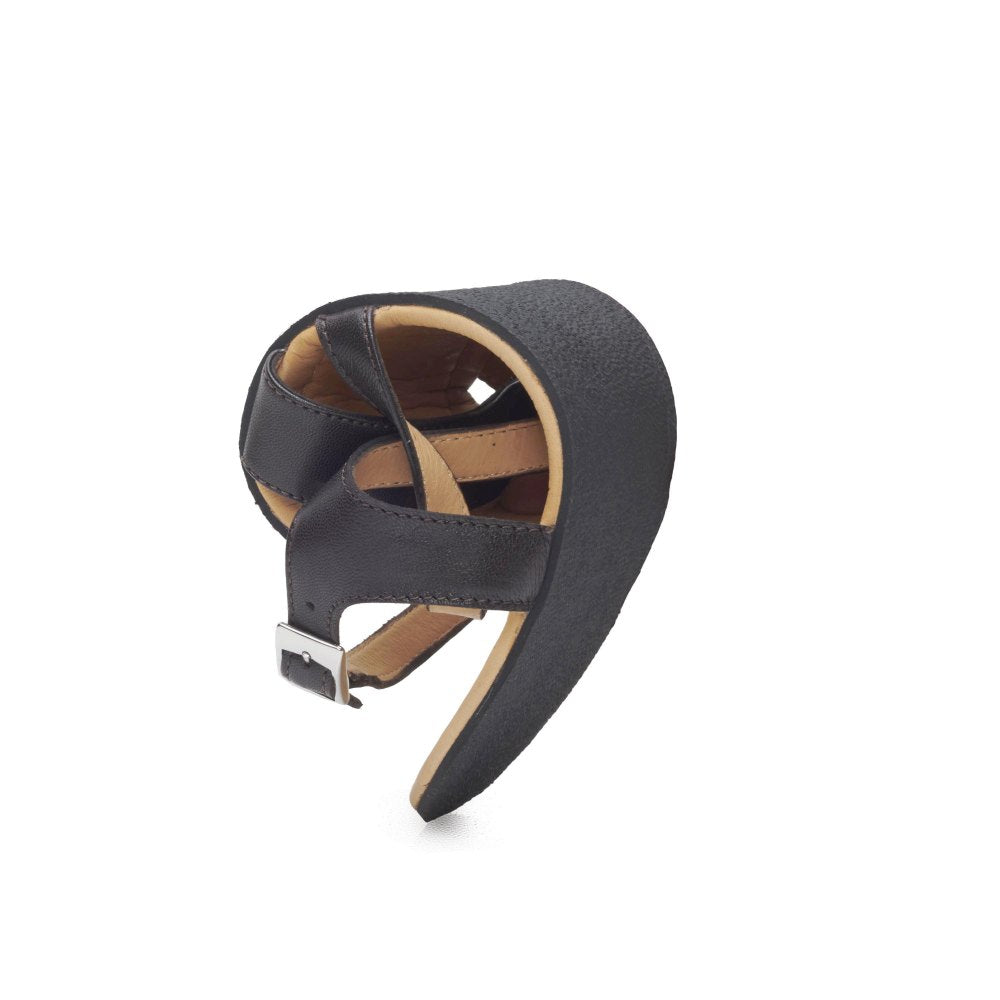 De QEE Dark Brown Sandale van ZAQQ is een chique leren creatie met een onderscheidende twist, met zichtbare banden en een gesp die elegant tegen een witte achtergrond wordt gepresenteerd. Deze modieuze barefoot-sandaal heeft een rubberen zool die ultiem comfort en flexibiliteit garandeert.