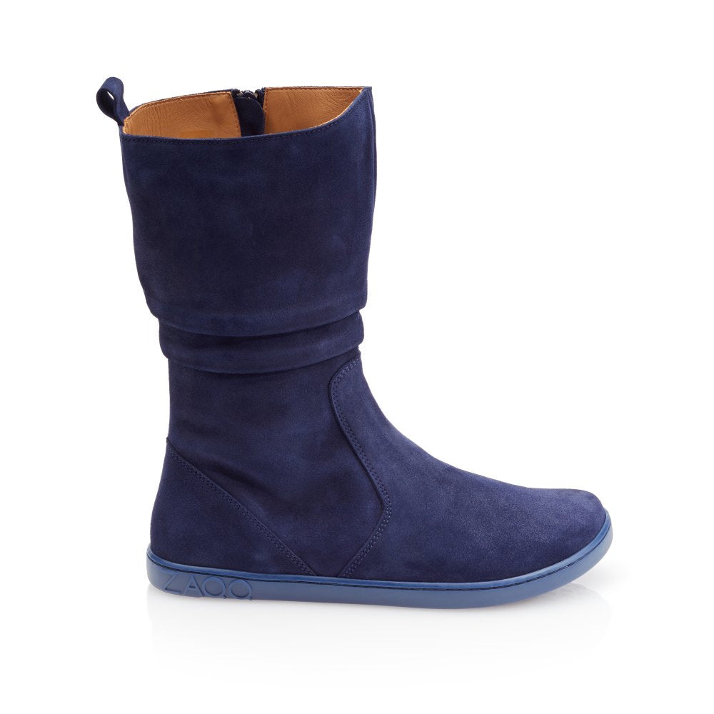 De ZAQQ QOM Blue Single Boot presenteert zich in marineblauw geitenveloursleer en een platte blauwe zool met het kenmerkende ZAQQ barvoetzoolontwerp. Hij heeft een gemiddelde schachthoogte, een casual snit, een zijrits en een lus voor gemakkelijk dragen, samen met een gegraveerd merkelogo nabij de hiel en een lichtbruin gevoerde binnenkant.
