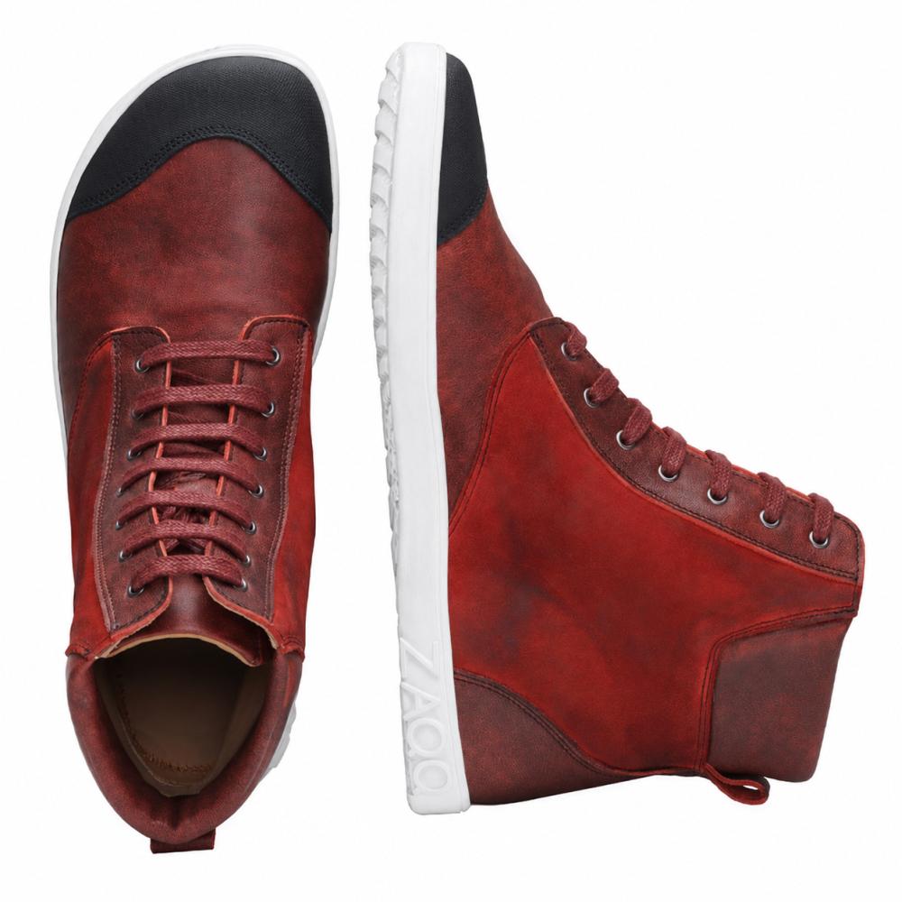 De CHICAQO Red van ZAQQ is een paar high-top sneakers van nappa- en suèdeleer met een zwarte teenkap en een witte, flexibele zool. Eén schoen staat rechtop voor een zijaanzicht, terwijl de andere zijn veters en het zwarte frontdetail van bovenaf benadrukt. De merknaam ZAQQ is zichtbaar op de zool.