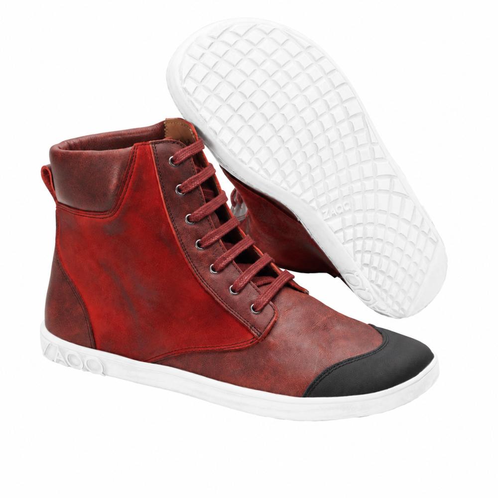 Wij presenteren de CHICAQO Red van ZAQQ: Deze stijlvolle high-top sneakers in felrood zijn gemaakt van hoogwaardig nappa- en suèdeleer. Ze hebben een gladde witte zool en een opvallende zwarte teenkap. Eén schoen staat rechtop, terwijl de andere schuin staat en zijn gestructureerde, flexibele zool tentoonstelt.