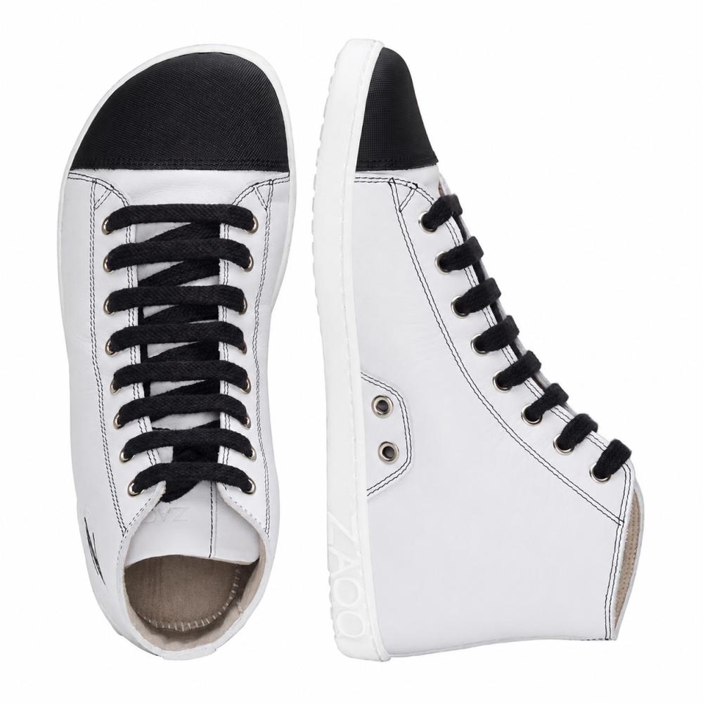 Wij presenteren de CHUQQS White van ZAQQ: een paar elegante witte high-top sneakers met zwarte veters en teenkappen. De linkerschoen is van boven naar beneden te zien, terwijl de rechterschoen rechtop staat en zijn zijprofiel toont. Deze sneakers zijn vakkundig gemaakt van nappaleer en hebben witte zolen met de merknaam ZOOZ.