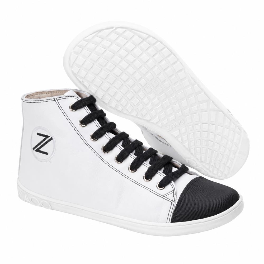 Wij presenteren de CHUQQS White van ZAQQ, een stijlvol paar high-top sneakers met een wit bovenwerk, zwarte teenkap en zwarte veters. Deze sneakers hebben een gestructureerde zool met rasterpatroon en tonen het Z-logo van het merk prominent aan de zijkant. De witte sneaker combineert naadloos klassieke stijl met modern comfort.