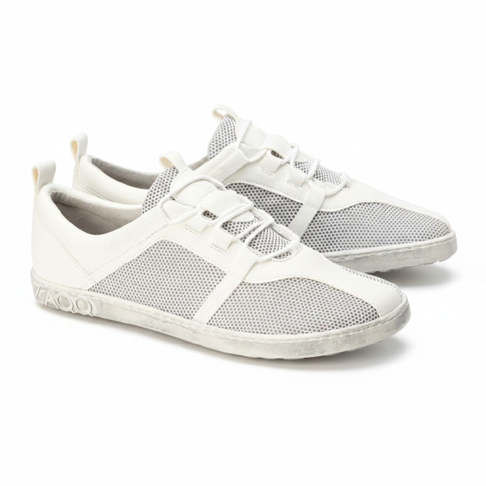 Ein Paar weiße MCQUENZIE Barfußschuhe von ZAQQ mit atmungsaktivem Mesh-Gewebe an den Seiten, weißen Schnürsenkeln und einer Gummisohle. Das Design umfasst eine solide Zehenkappe für mehr Komfort.
