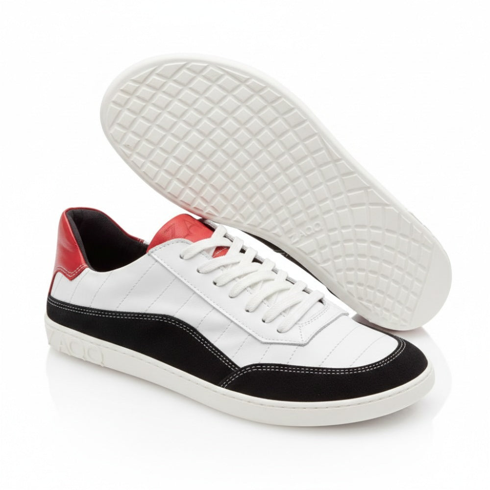 Wir präsentieren den QAMPION Black White, ein elegantes Paar ZAQQ Barfuß-Sneaker mit weißem Obermaterial aus Leder, schwarzen Akzenten aus Veloursleder und kräftigen roten Fersenlaschen. Die flexible Sohle zeigt ein geometrisches Muster, wobei der ikonische ZAQQ-Name stolz auf der Seite und der Sohle prangt.