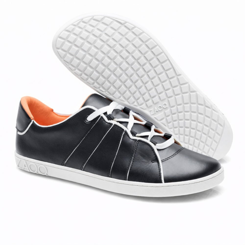 Wir präsentieren den ZAQQ QQQ Low Black White: ein Paar schwarze Leder-Sneaker für außergewöhnlichen Tragekomfort. Diese Barfußschuhe haben weiße Sohlen und Schnürsenkel, eine orangefarbene Innenseite und ein Sohlendesign mit Gittermuster. Die elegante Prägung des Wortes ZAQQ ziert die Ferse.