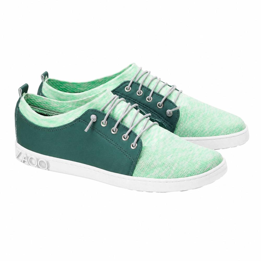 We presenteren de QRIS Green Sneaker van ZAQQ: een stijlvol paar mintgroene vrijetijdsschoenen met een witte zool, donkergroene accenten en witte veters. Deze sneakers kenmerken zich door een modern, sportief design en zijn ideaal voor elk avontuur.
