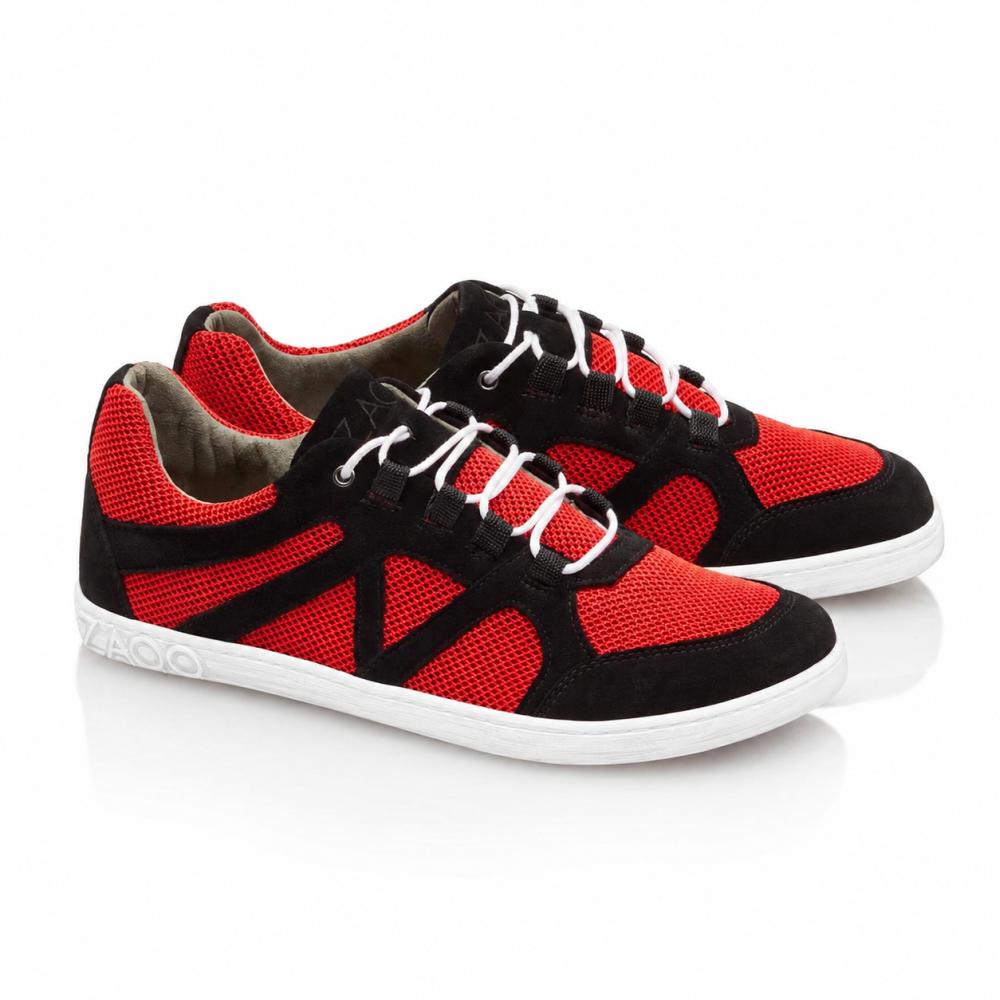 Een paar QUSQO Red-sneakers van ZAQQ met een combinatie van rode mesh-inzetten en zwarte suède accenten, compleet met witte veters en een witte zool. Deze hardloopschoenen hebben een uniek golvend stikselontwerp aan de zijkant en de merknaam elegant op de hiel aangebracht.