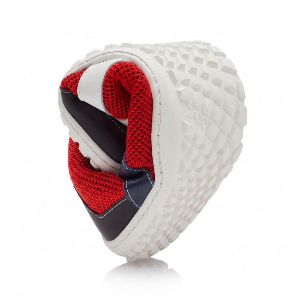 Der Laufschuh ZARQA Red von ZAQQ besticht durch ein flexibles, spiralförmig gedrehtes Design mit einem leuchtend roten Mesh-Innenleben und einer strapazierfähigen, strukturierten schwarzen Sohle für optimalen Halt. Dieser stylische Barfußschuh wird durch markante schwarz-weiße Akzente auf der Außenseite hervorgehoben.